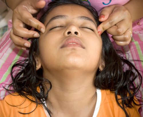 Woman massaging girl's head