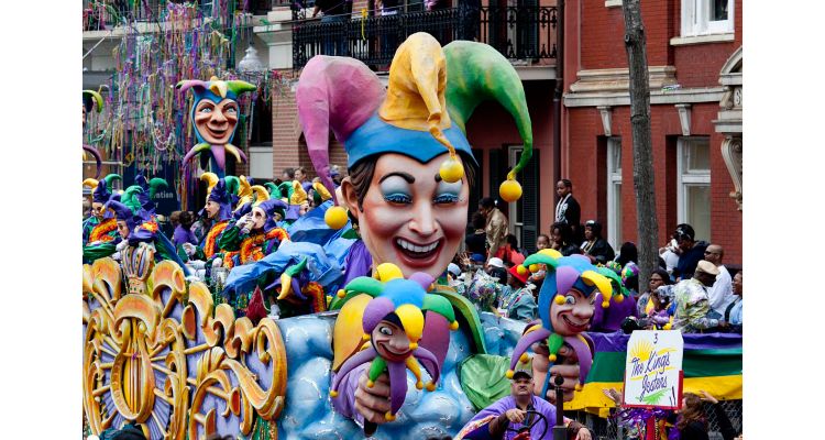 Brightly colored float with a jester head in a Mardi Gras parade.
