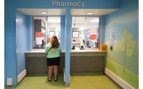 Woman standing at pharmacy counter