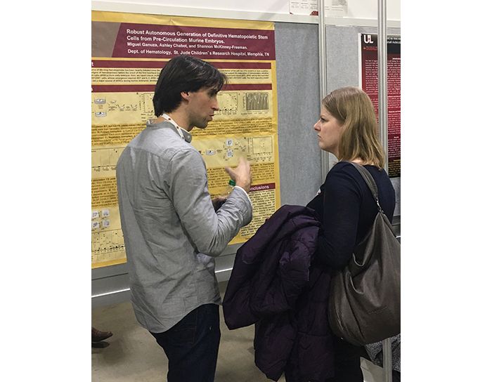 two people standing with a poster