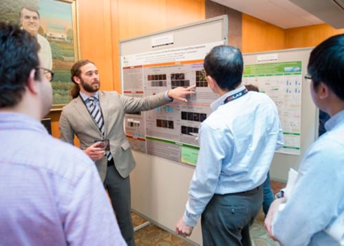 Photo of David Protter discussing his research during the National Graduate Student Symposium poster session.