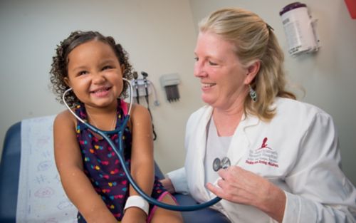 Faculty member Kim Nichols, MD, with young female patient