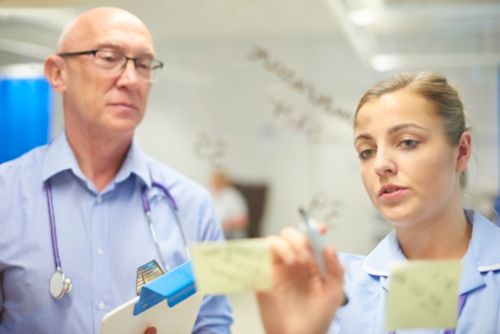 Equipo médico que evalúa el contenido escrito en una pizarra blanca