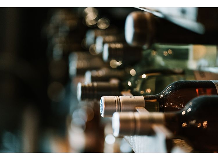 Close up of up wine bottles laying on a rack