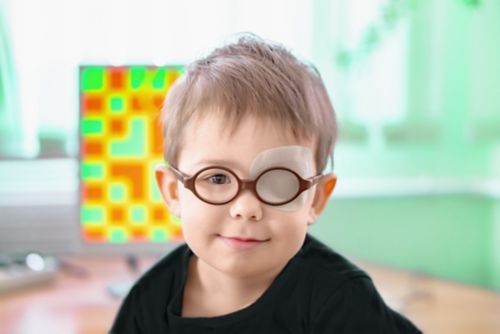 A little boy wearing glasses and an eye patch