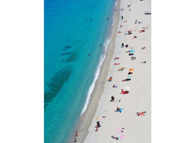 Aerial view of white sandy beach and aqua blue ocean with beach goers