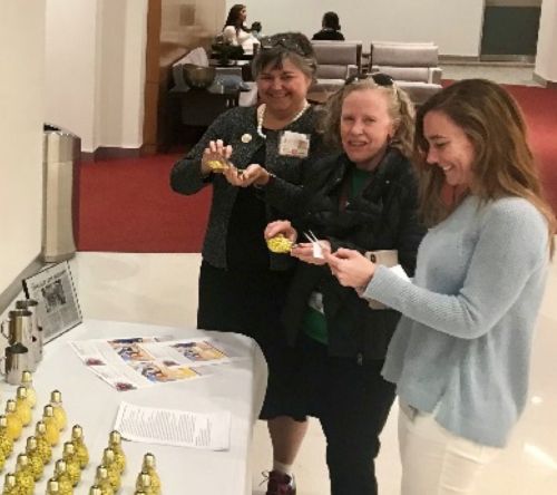 St. Jude employees smiling and holding lighbulbs full of candy