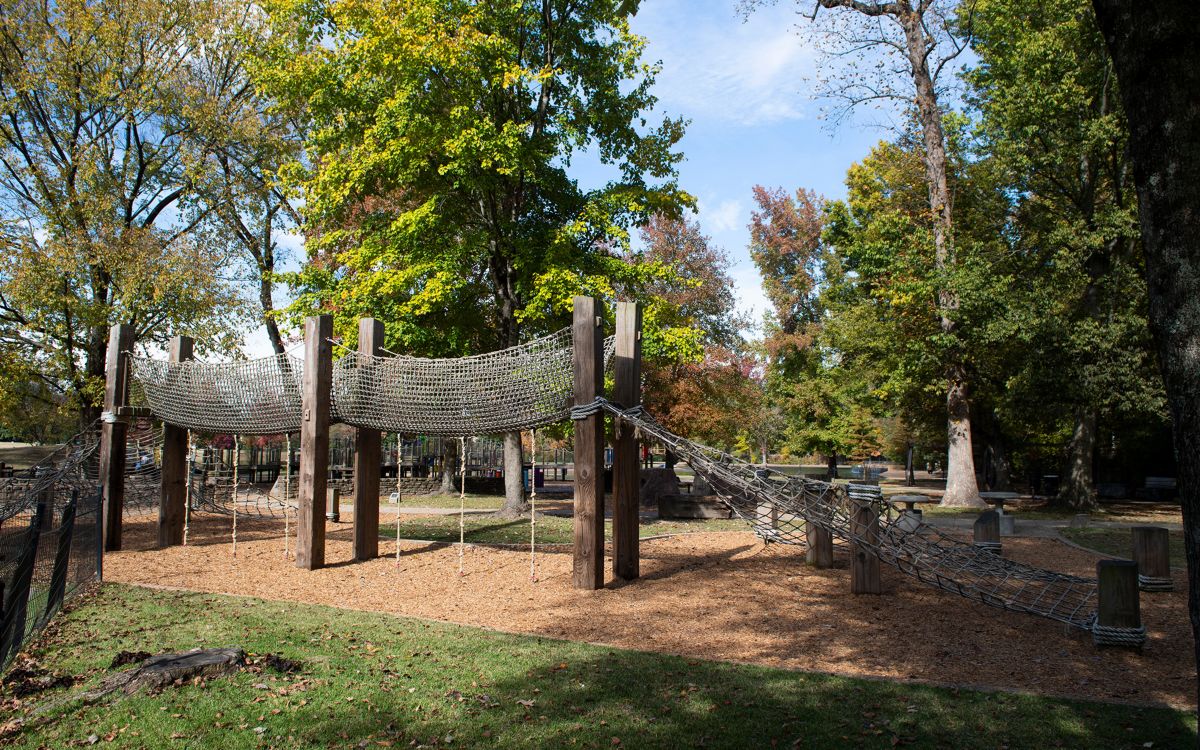 Large playground structure in a park on a sunny day.