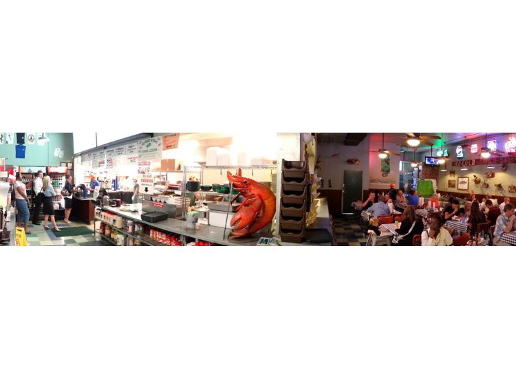 Panoramic photo showing the front counter and seating area in a Flying Fish restaurant.