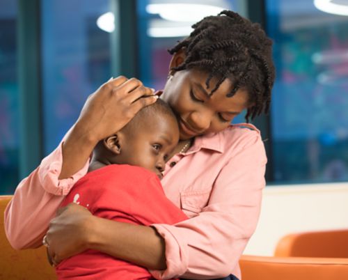 Pediatric cancer patient hugging mom