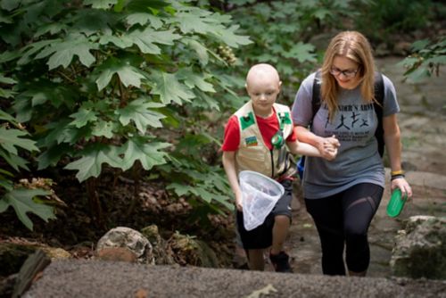 The stoma should not be painful once healed. Children should be able to do most regular activities. In this photo, a child with a G tube walks along a trail with his mom looking for insects.