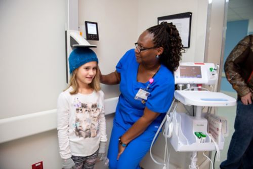 Childhood cancer survivors may develop growth problems as a result of certain cancer treatments. In this image, cancer center staff measures a survivor’s height.