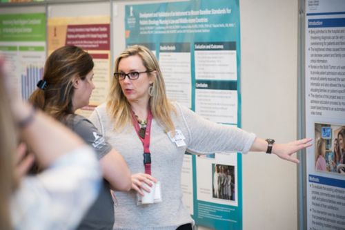 Photo of Dana McLure and another woman discussing a poster