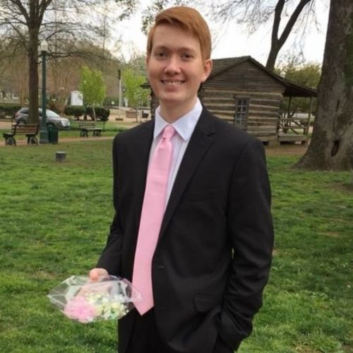 A male cancer patient in a suit holding a corsage before attending prom.