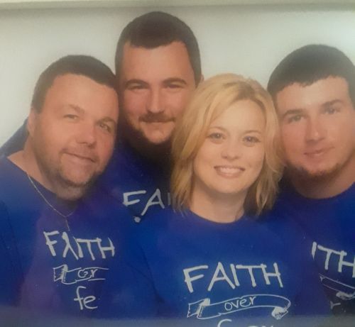 Patient and family, four people total, wearing purple t-shirts that say "Faith Over Fear."