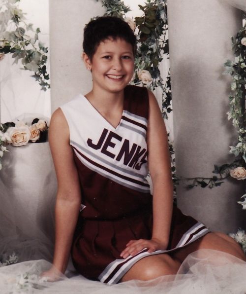 Portrait of the patient in a cheerleader outfit sitting in front of a column