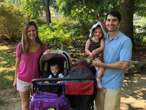 A family standing in front of some trees