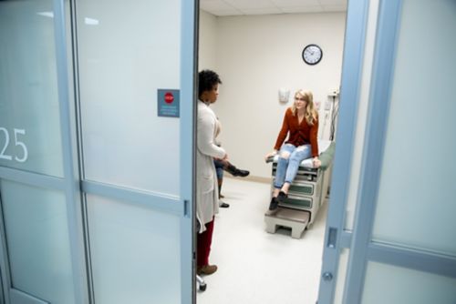 A survivorship care plan is specific to the patient for whom it was developed. In this image, a childhood cancer survivor talks with a care provider in a clinic room.