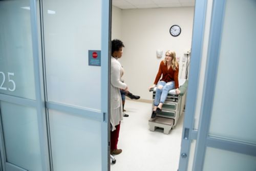 Un plan de soins pour les survivants est spécifique au patient pour lequel il a été élaboré. Sur cette image, un survivant d'un cancer de l'enfance discute avec un prestataire de soins dans une salle d'examen clinique.