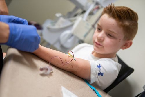 Close up of male child patient receiving blood draw