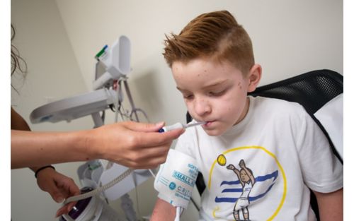 Child getting temperature taken by nurse