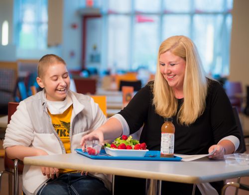 Clinical nutritionist reviews healthy food choices with pediatric cancer patient