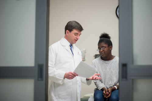 Paciente con cáncer pediátrico se reúne con el médico en la clínica.