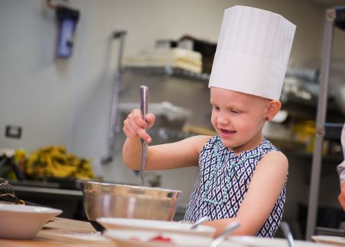 Un patient atteint d'un cancer pédiatrique remue de la pâte à crêpes.