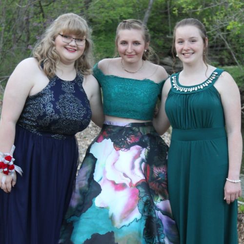 Tres adolescentes con sus vestidos antes del baile de graduación.