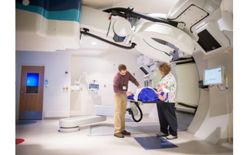 Radiation therapist performs scan on patient