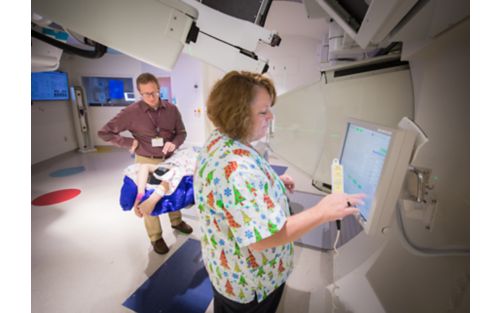 Radiation therapist performs scan on patient