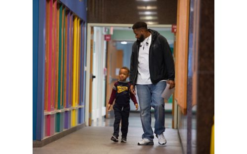 Male patient walking with father down hospital corridor