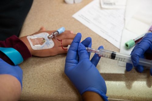 The nurse tests the IV to make sure it is working properly.