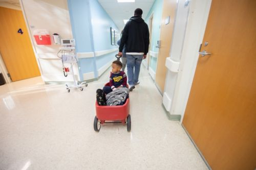 Um médico pode esperar até que todos os resultados dos exames estejam prontos antes de discutir as informações. Dependendo do tipo de exame, pode demorar algumas horas a algumas semanas até que os resultados estejam prontos. Nesta foto, um pai puxa seu filho por um corredor hospitalar em um carrinho vermelho.