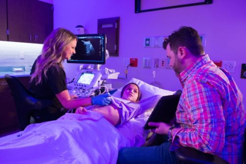 Paciente de câncer pediátrico passa por ultrassom com o pai perto