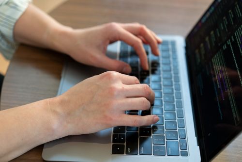 Hands typing on a laptop.
