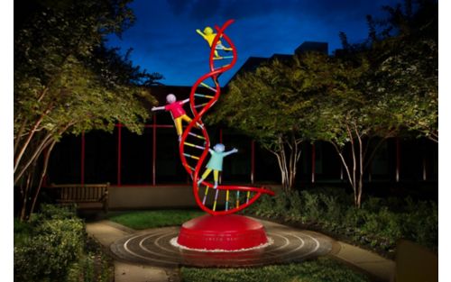 statue of children playing on a dna strand