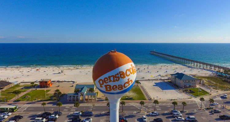 Pensacola Beach Florida water tower in front of sandy beach, blue ocean and boardwalk