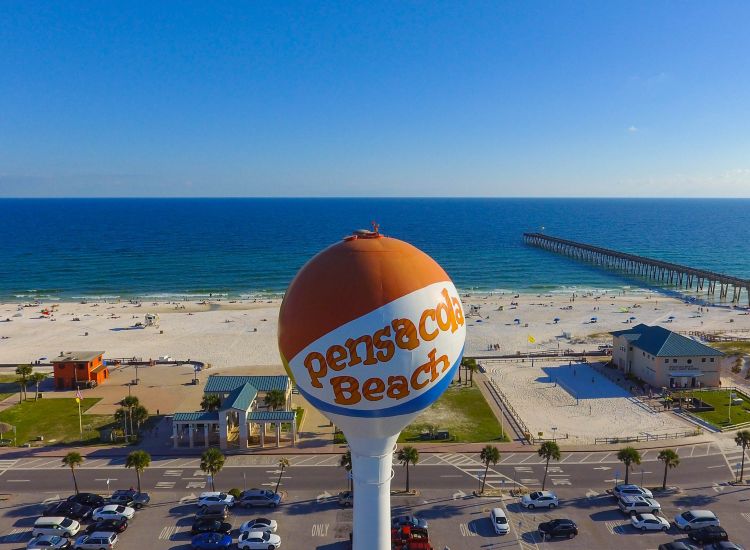 Pensacola Beach Florida water tower in front of sandy beach, blue ocean and boardwalk