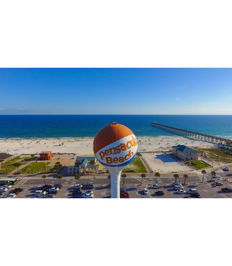 Pensacola Beach Florida water tower in front of sandy beach, blue ocean and boardwalk