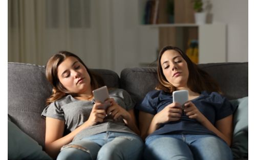 Image of two girls on their phones