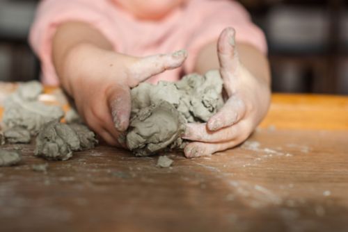 Child playing with pottery clay
