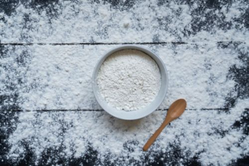 flour in a bowl and wooden spoon
