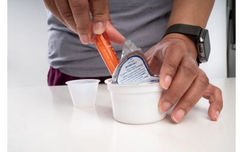 Person placing medicine in cup