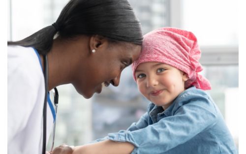 Female doctor smiles at female child cancer patient