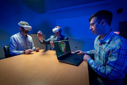 Drs Abramson and Davidoff wearing virtual reality headsets while Chris Goode runs the lap top that enables then to see a tumor.