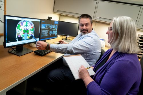 two people looking at brain scan on computer