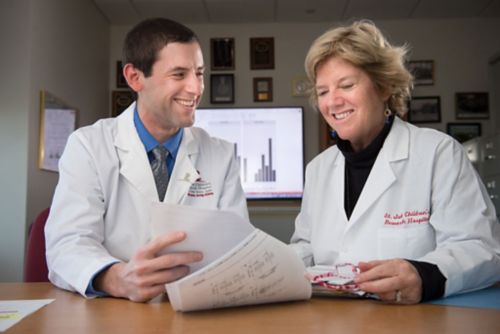 Two people reading a report. 