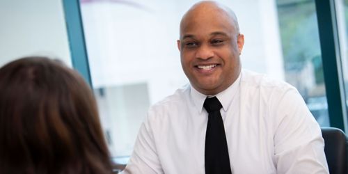 photo of smiling man in dress shirt and tie