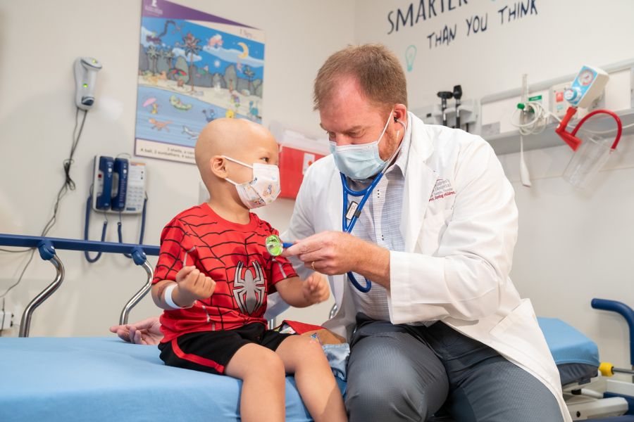 Doctor checking heart beat on child patient in clinical setting